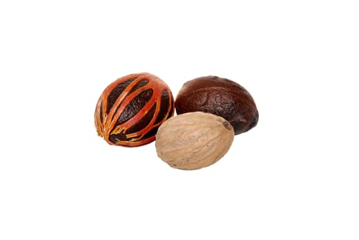Three whole nutmegs - covered in mace, in case and seed, isolated on a white background