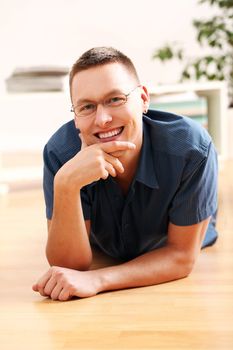 Portrait of lying young man in glasses at home