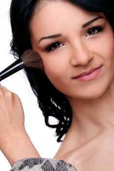 Portrait of young and beautifull girl with brush on her face