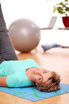 slim mid aged woman do her fitness exercises at home