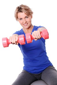 Cute mid aged women do exercises with dumbbells on a abs ball