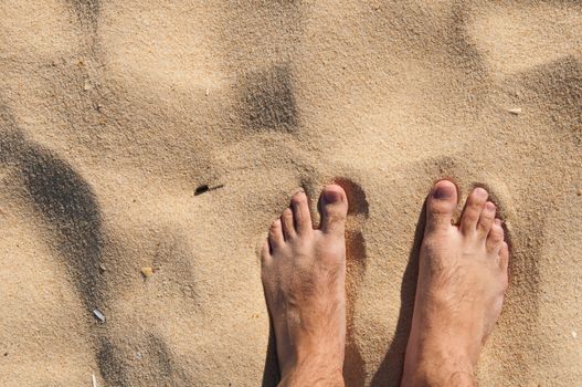 young man barefoot on a sandy beach in Algarve, Portugal