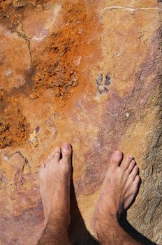 young man barefoot on rocky beach in Algarve, Portugal