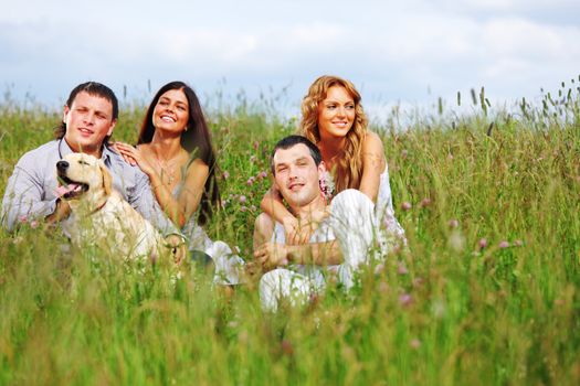 friends and dog in green grass field