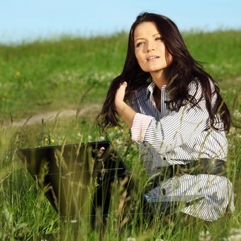 girl with laptop on green grass