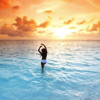 Young woman enjoy sunset in ocean water