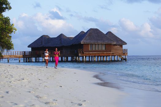 Fitness sport women running on beach in morning