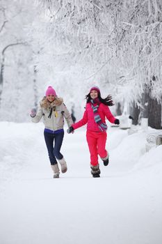 two winter women run by snow frosted alley