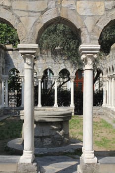 Cloister or courtyard of 12th century church with well in Genoa, Italy. 
