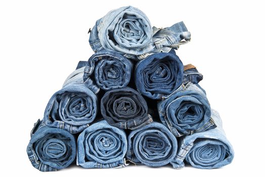 Rolled jeans arranged in a pyramid and isolated over a white background