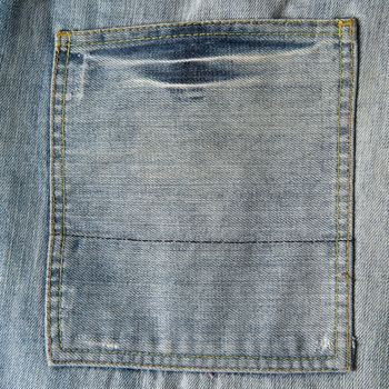 Closeup from the pocket of an old and worn blue jeans