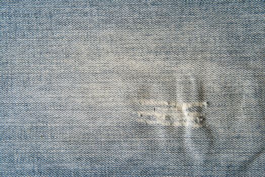 Old and worn blue jeans pattern background in a king size

