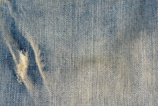 Old and worn blue jeans pattern background in a king size
