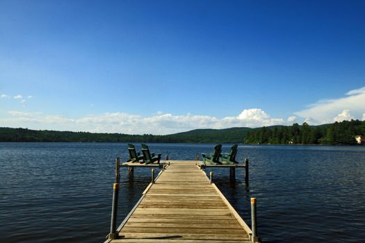 Lake side deck with chairs and summer sunshine