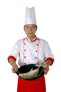 chef present raw fish on a black frying isolated on white background