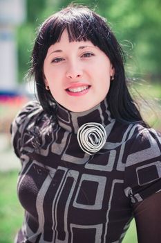 Beautiful smiling young woman outdoors on a warm summer day