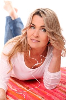Beautiful Mid aged woman listening music with headphones