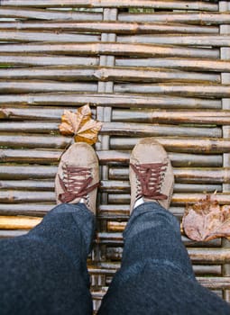 Feet walk over wooden bridge