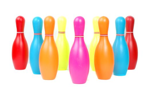 Row of colorful toy plastic bowling pins isolated on white background