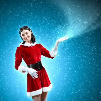 Portrait of beautiful girl wearing santa claus clothes on red background