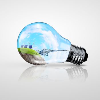 Electric light bulb and a plant inside it as symbol of green energy