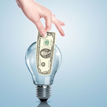 Hand and money inside an electric light bulb