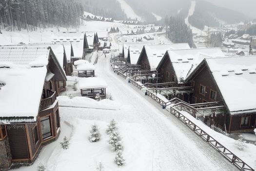 winter street in alpine village under snowfall