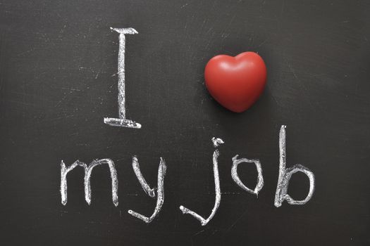 I love my job -  positive concept handwritten on black chalkboard with volume red heart symbol