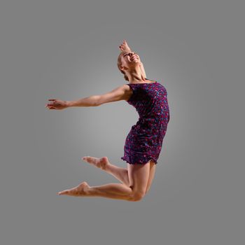 dancer jumping on a gray background, having a fun