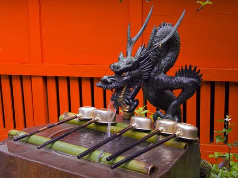 traditional sculpture of Japanese dragon near the temple entrance, the place is used for wash hands before enter