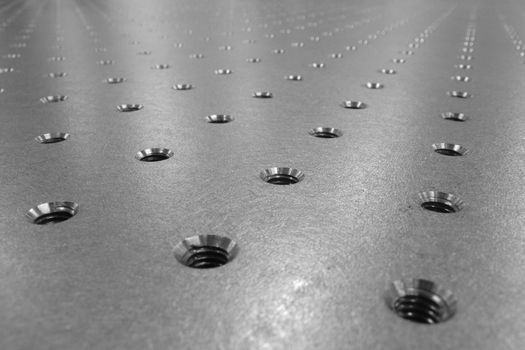 steel surface of optical table with holes net, used in optical science and laser industry
