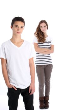 Three quarter portrait of a relaxed serious teenage boy posing with his sister standing full length in the background isolated on white