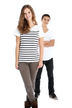 Full body studio portrait of two smiling young trendy teenagers in smart casual clothes with the girl in the foreground and boy behind isolated on white