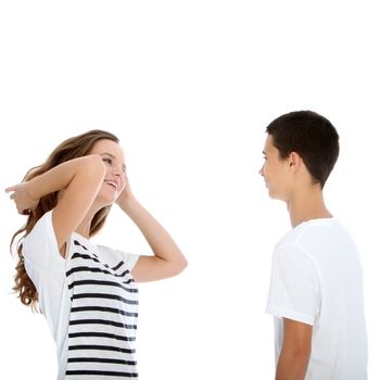 Young teenage couple talking with the girl flicking her hair and laughing flirtaceously isolated on white Young teenage couple talking with the girl flicking her her and laughing flirtaceously isolated on white