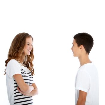 Attractive young teenage boy and girl standing sideways facing each other chatting isolated on white