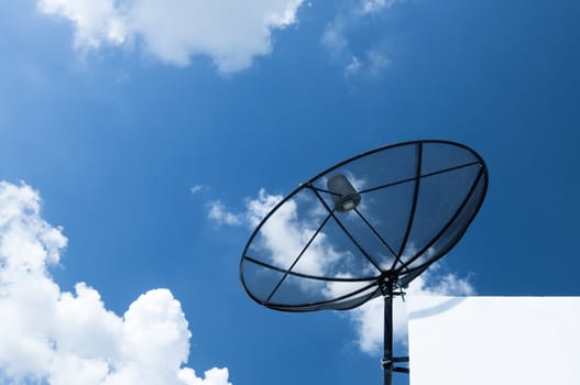 Satellite dish on cloudy blue sky