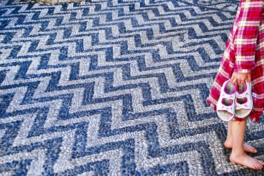 Floor in a zigzag pattern made with dark blue and light gray small beach stones. My granddaughter Julia thoughr it was lovely to walk on the floor barefoot. Image is shot in the old town of Rhodes, 5/10-2010 