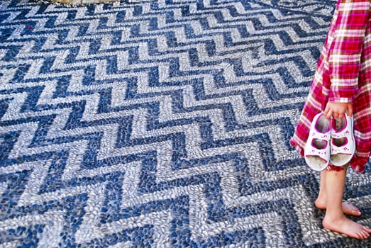 Floor in a zigzag pattern made with dark blue and light gray small beach stones. My granddaughter Julia thoughr it was lovely to walk on the floor barefoot. Image is shot in the old town of Rhodes, 5/10-2010 