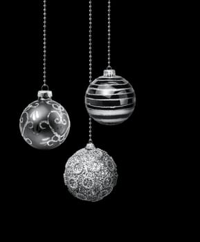 Three silver decoration Christmas balls hanging black background isolated