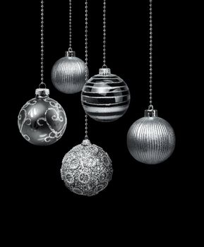 Five silver decoration Christmas balls hanging black background isolated