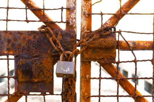 Metal door with rusty chain and key locked. Concept security