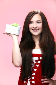 Portrait of young and beautiful christmas girl in red with gift