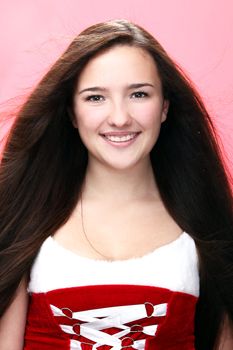 Portrait of young and beautiful smiling christmas girl in red