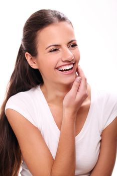 Cute and young smiling woman with white teeth touching her face