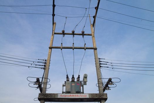 Electricity post with transformer on blue sky background