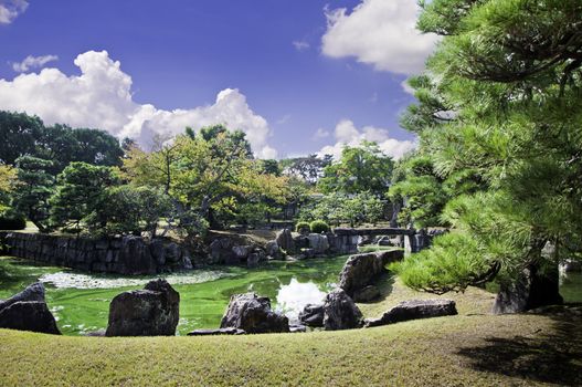 Pond and stone tea lights in a Japanese garden. 