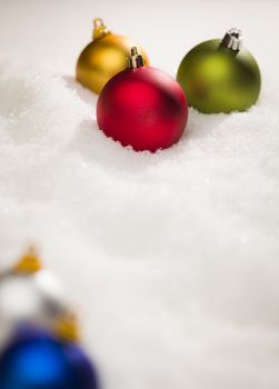 Beautiful Various Colored Christmas Ornaments on Snow Flakes Room For Your Own Text.