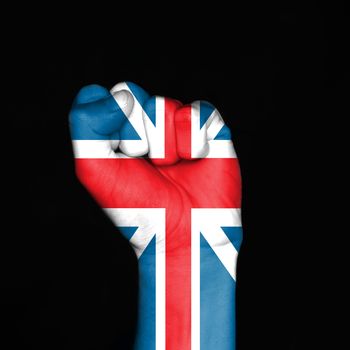 England flag on fist over black background. Symbol of strength.