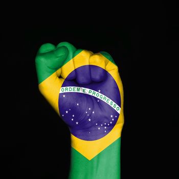 Brazil flag on fist over black background. Symbol of strength.