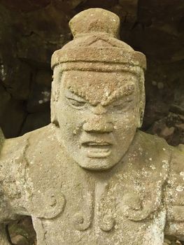 ancient sculpture of warrior deity close-up of ancient sculpture of warrior deity near old Japanese Shinto temple (shrine)